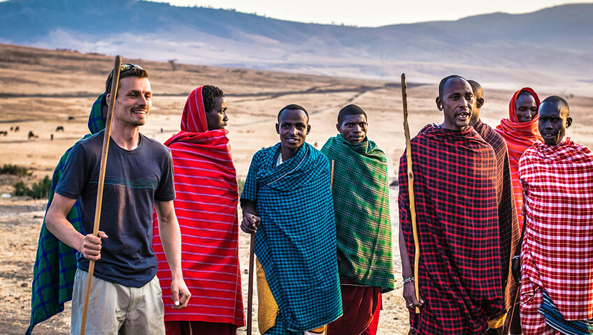 Traveller meeting local guides in a sweeping African landscape